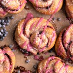 Elderberry twist buns on a baking sheet with fresh elderberries