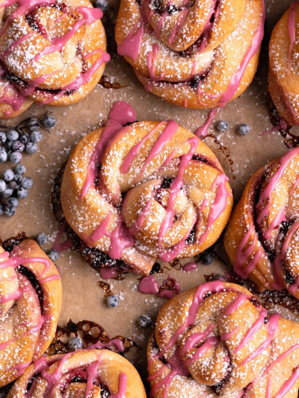 Elderberry twist buns on a baking sheet with fresh elderberries