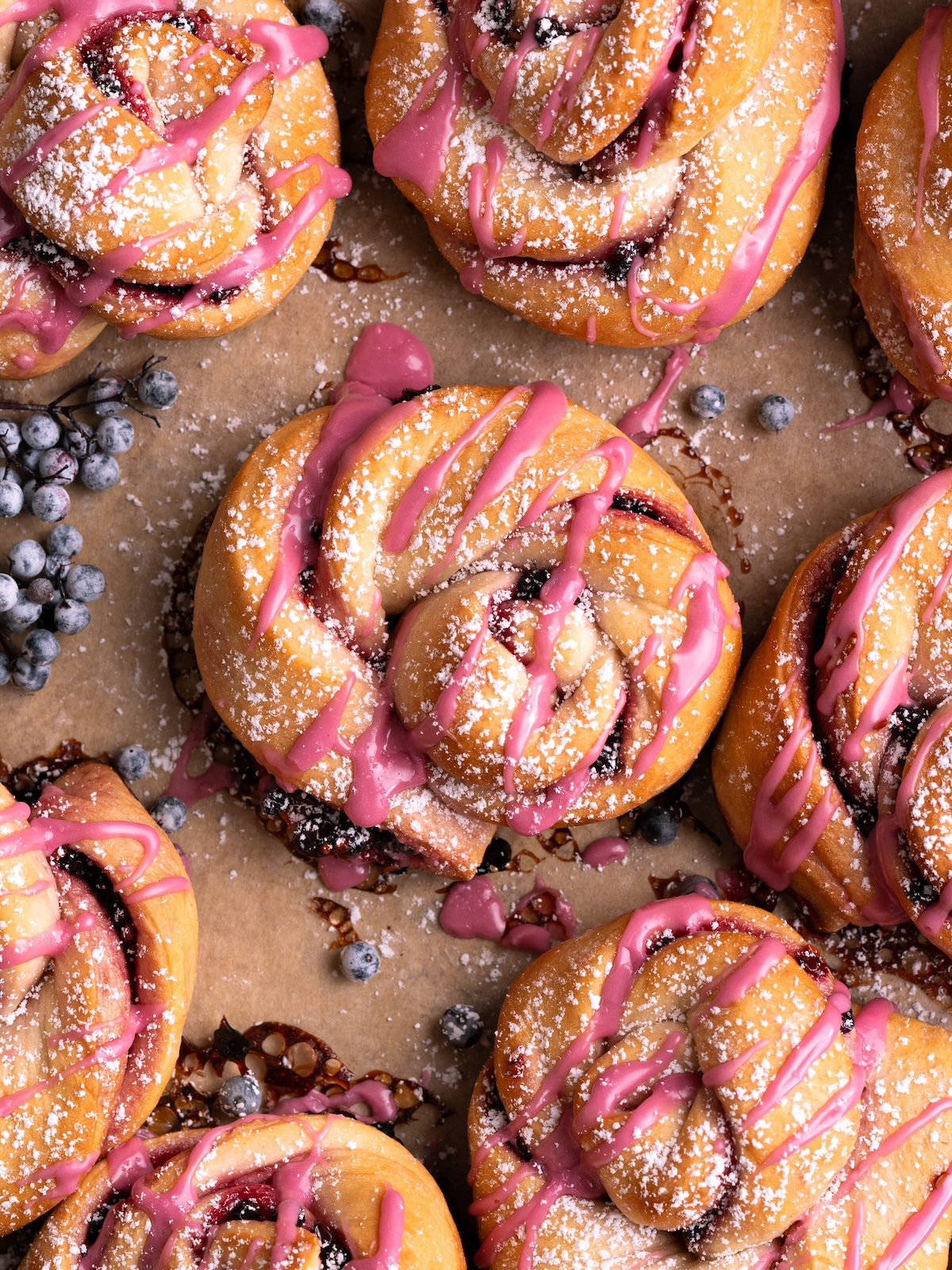 Elderberry twist buns on a baking sheet with fresh elderberries