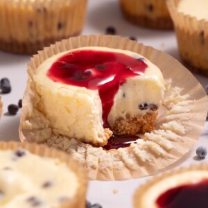 A miniature elderberry cheesecake with elderberry sauce dripping down the side