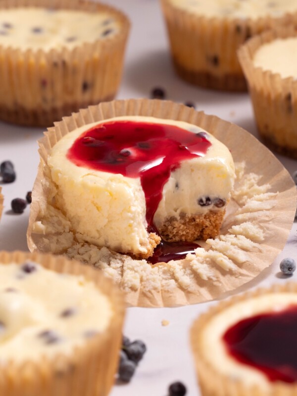 A miniature elderberry cheesecake with elderberry sauce dripping down the side