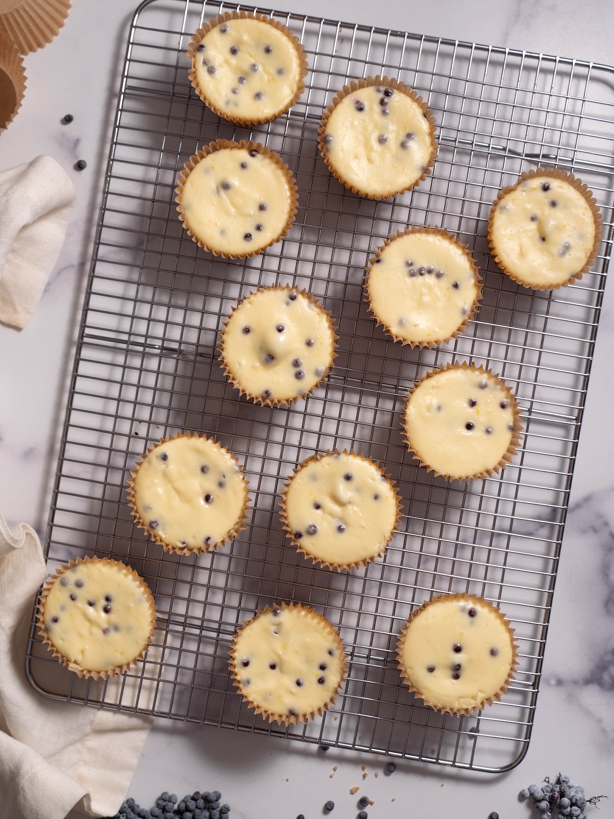Individual elderberry cheesecakes on a cooling rack