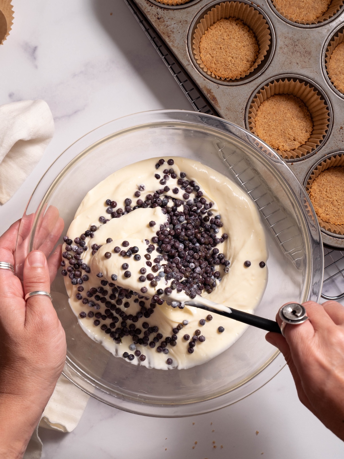 Folding fresh blue elderberries into cheesecake batter