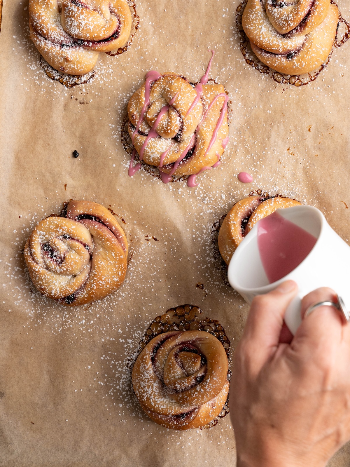 Pouring elderberry glaze onto twisted buns