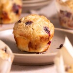 A sourdough huckleberry muffin with crunchy sugar topping on a plate