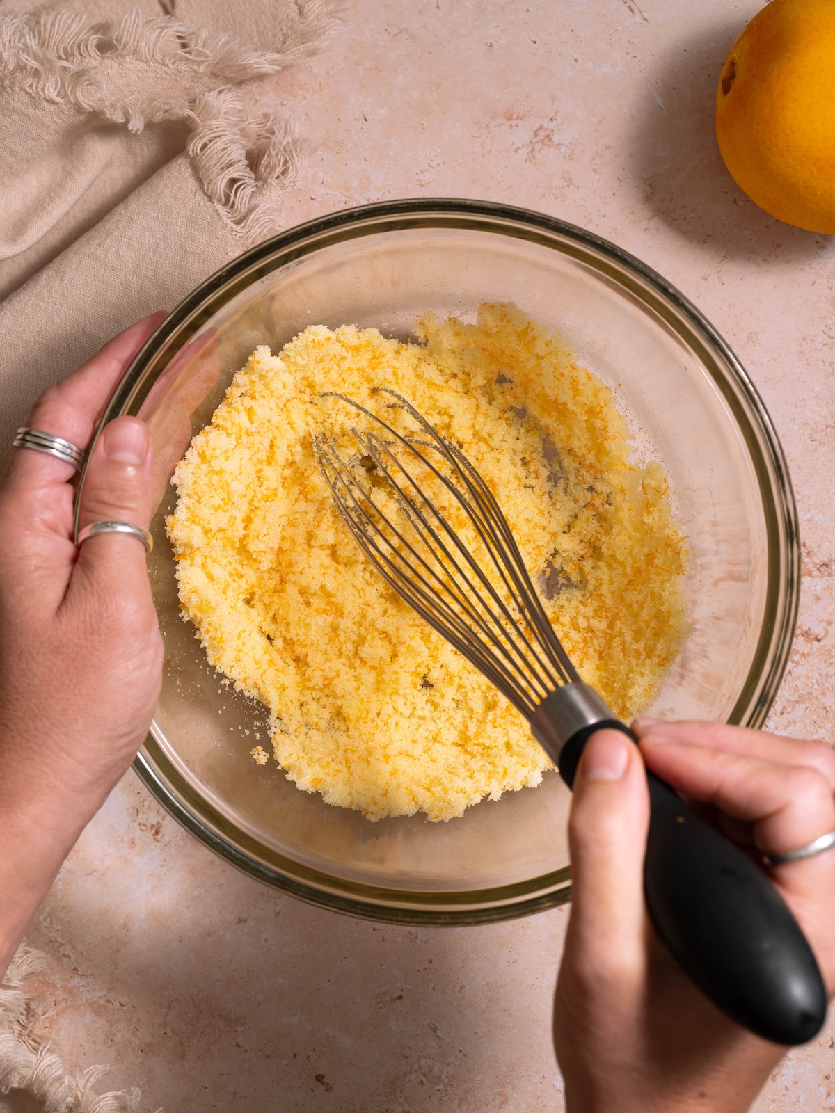 Mixing orange zest with sugar in a bowl