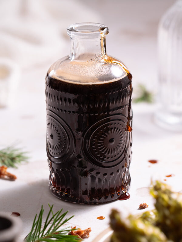 A glass jar filled with dark pine cone syrup
