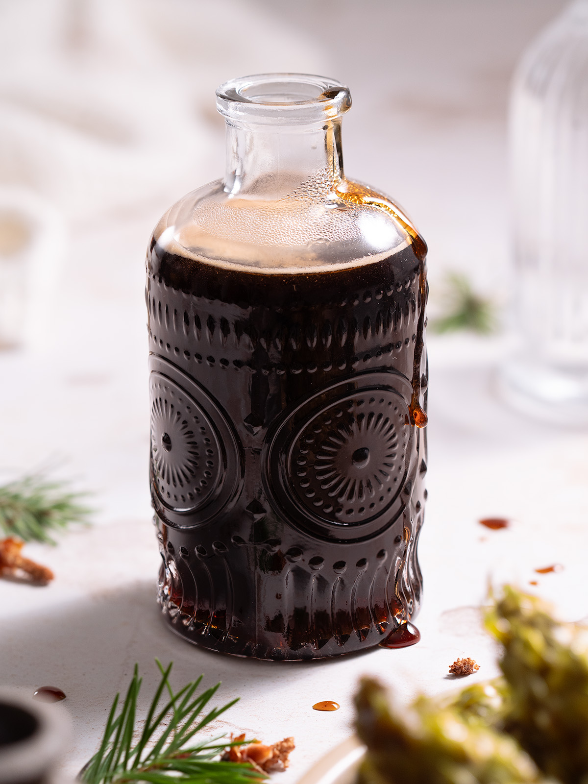 A glass jar filled with dark pine cone syrup