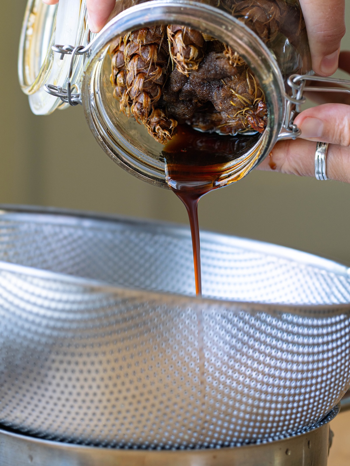 Straining Douglas fir pine cones out of syrup