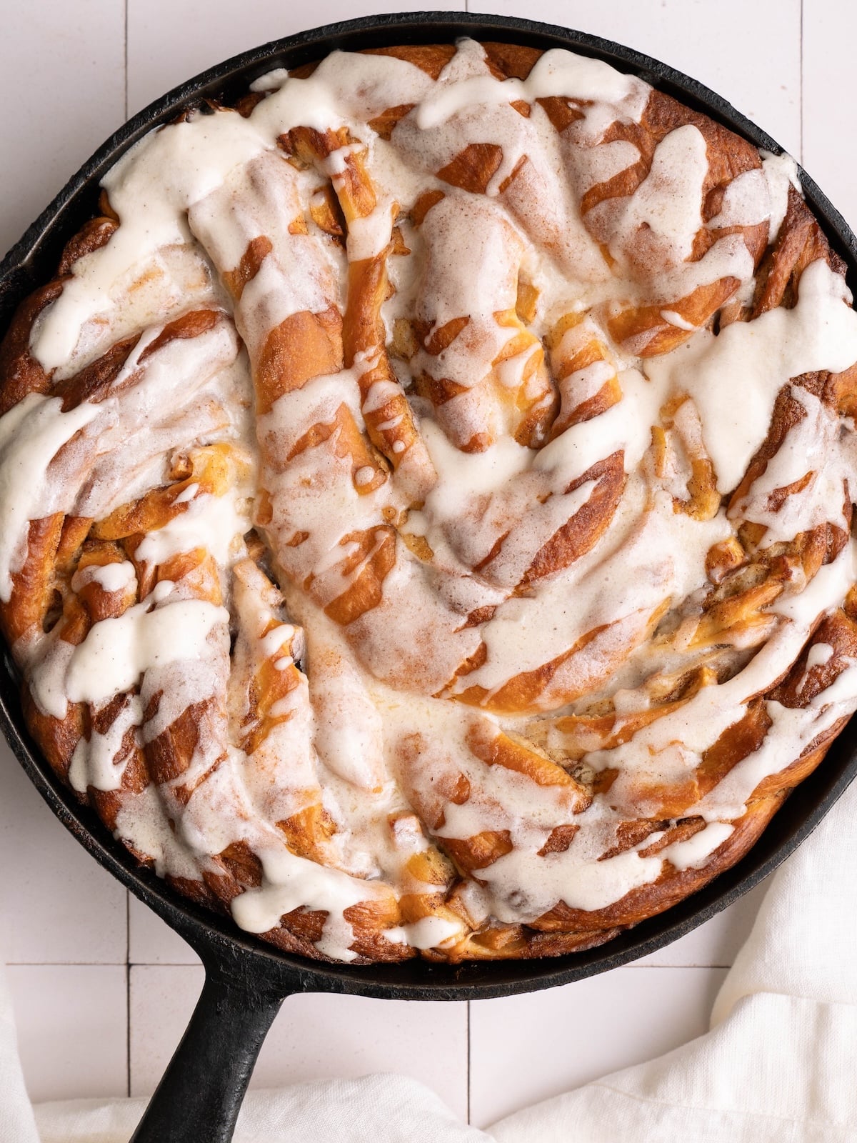 A giant apple cinnamon roll in a cast iron pan