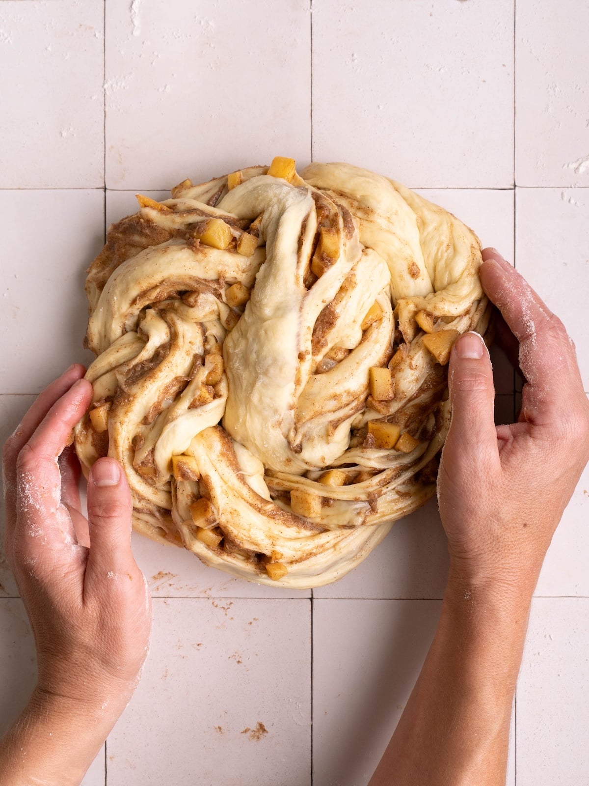 Shaping apple cinnamon roll into a spiral twist shape