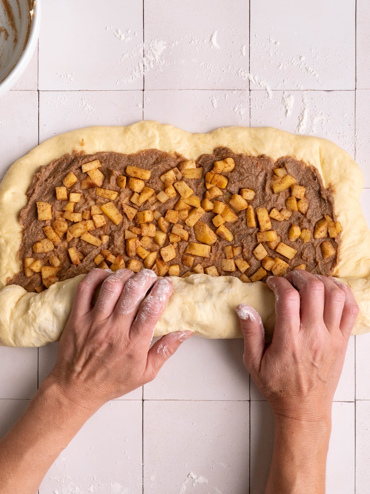 Rolling up an apple cinnamon roll