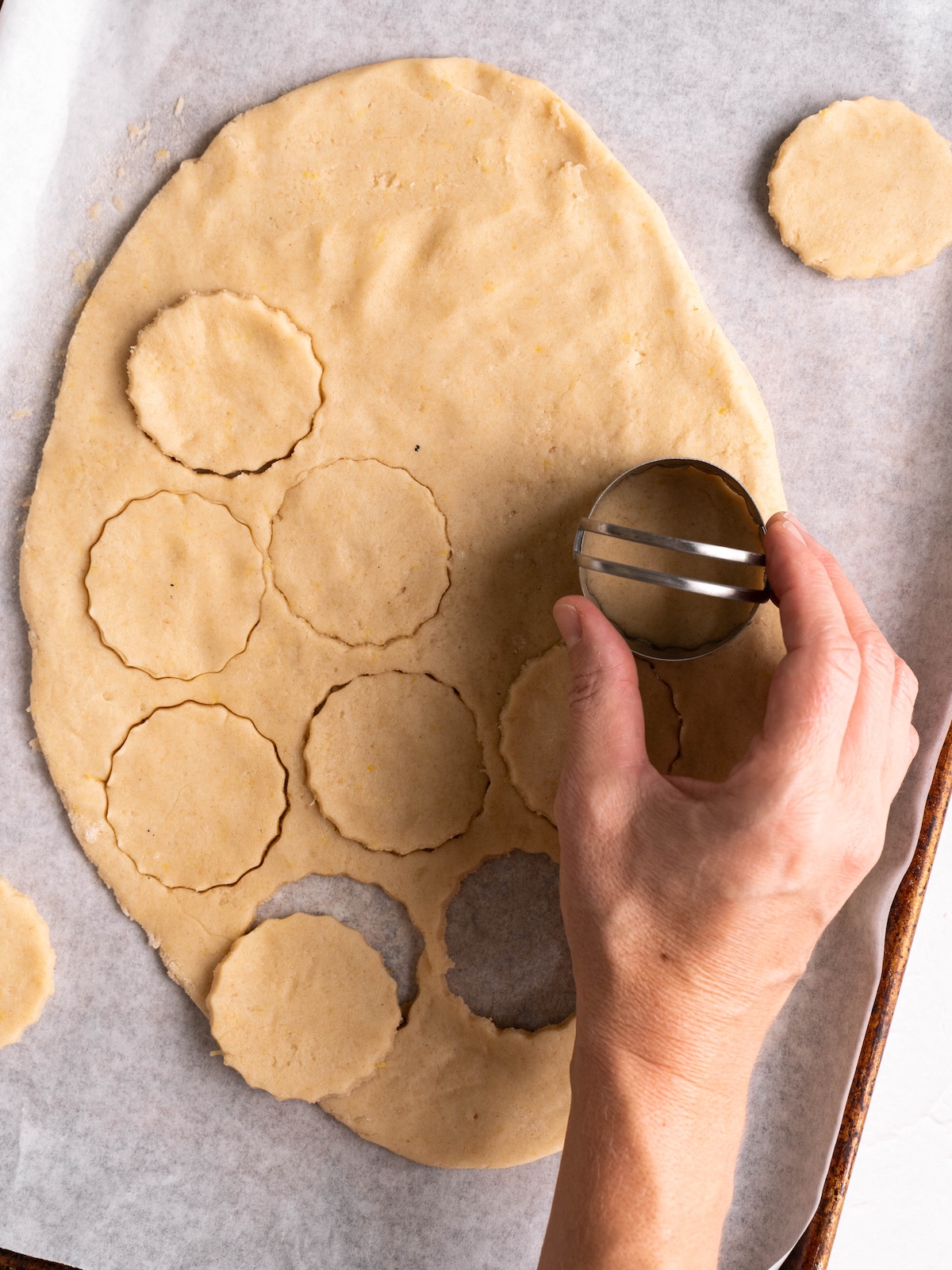Cutting scalloped circles out of shortbread cookie dough