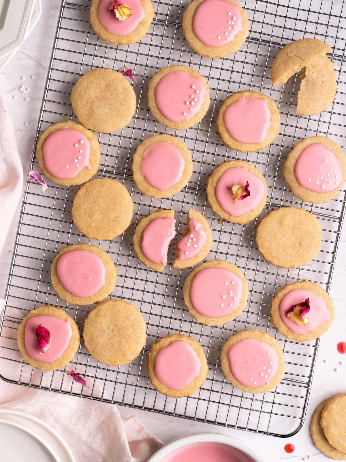 Shortbread cookies with pink hawthorn glaze on a cooling rack