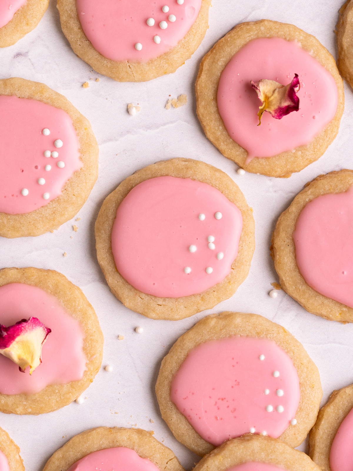 Lemon shortbread cookies covered in pink hawthorn berry glaze