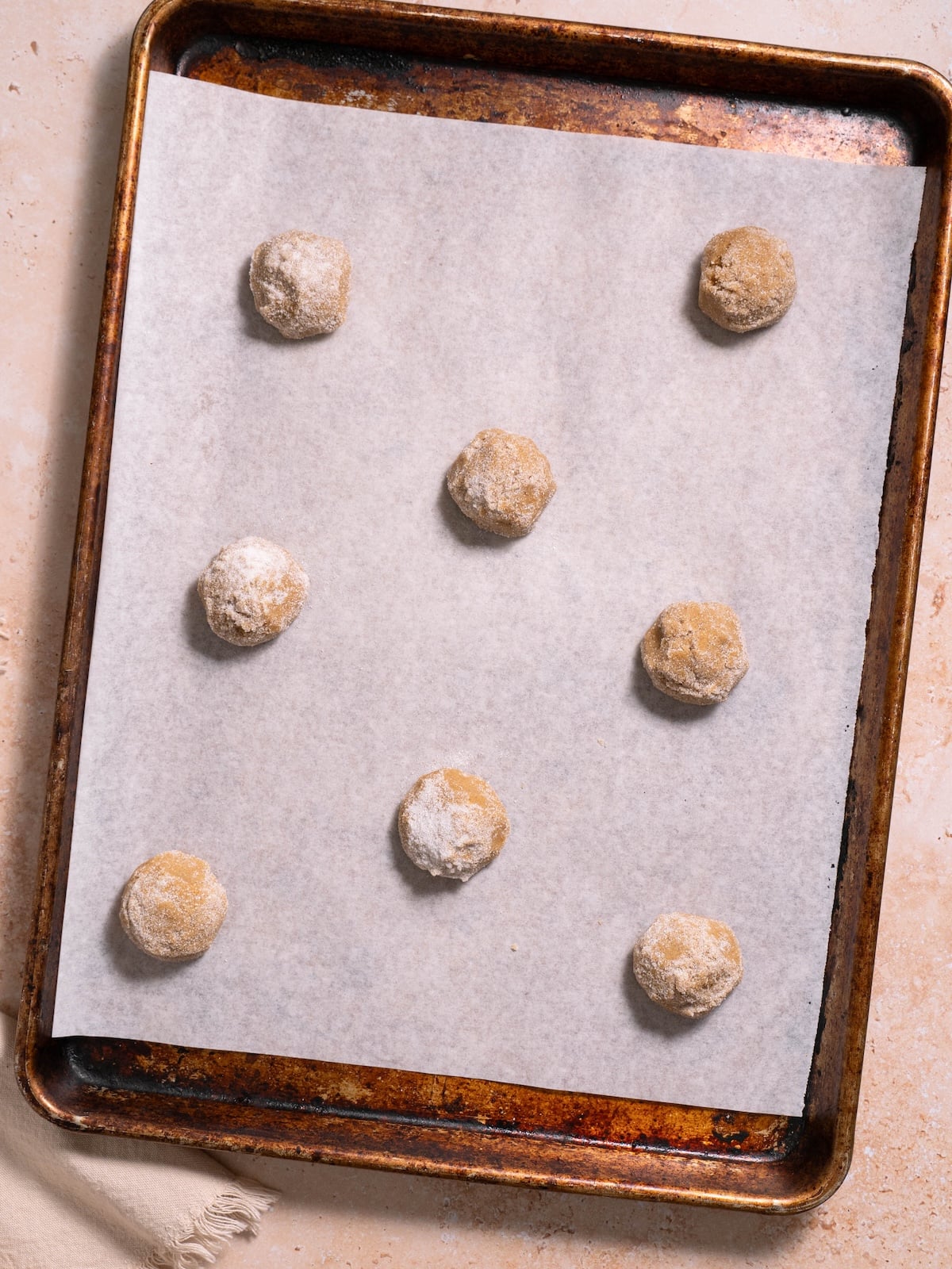 Molasses crinkle cookies on a cookie sheet before baking