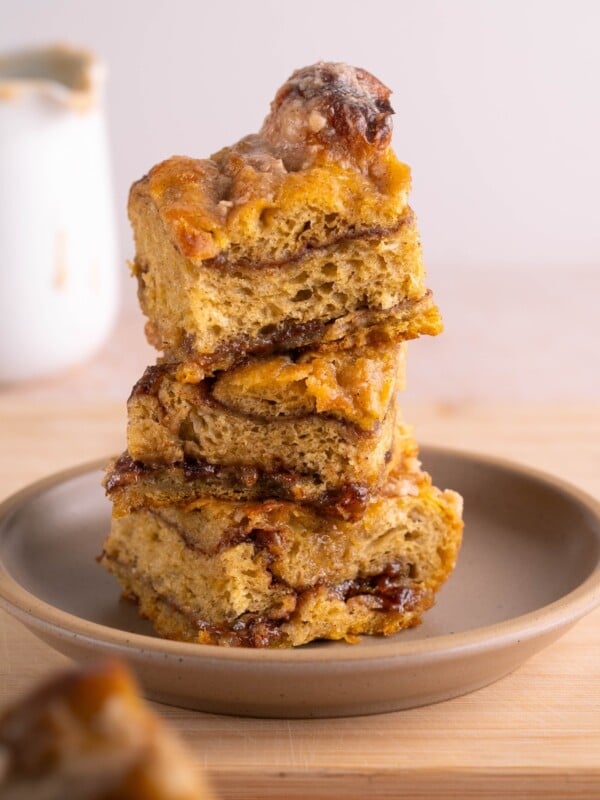 Thick slices of pumpkin cinnamon roll focaccia stacked on a plate