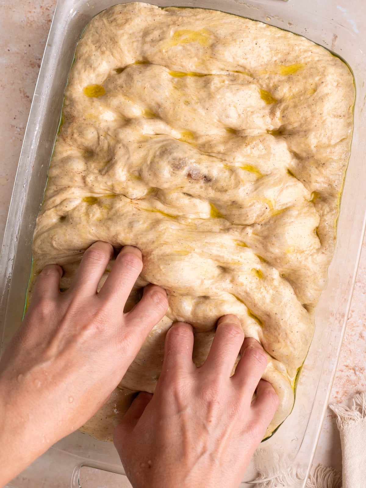 Dimpling pumpkin focaccia bread with fingers