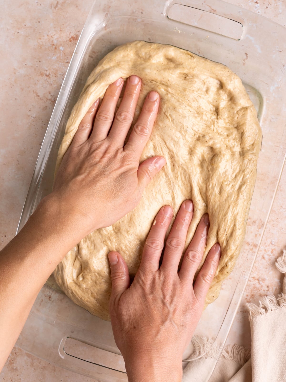 Spreading focaccia dough into a pan